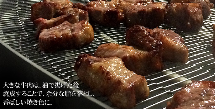 大きな牛肉は、油で揚げた後焼成することで、余分な脂を落とし、香ばしい焼き色に。